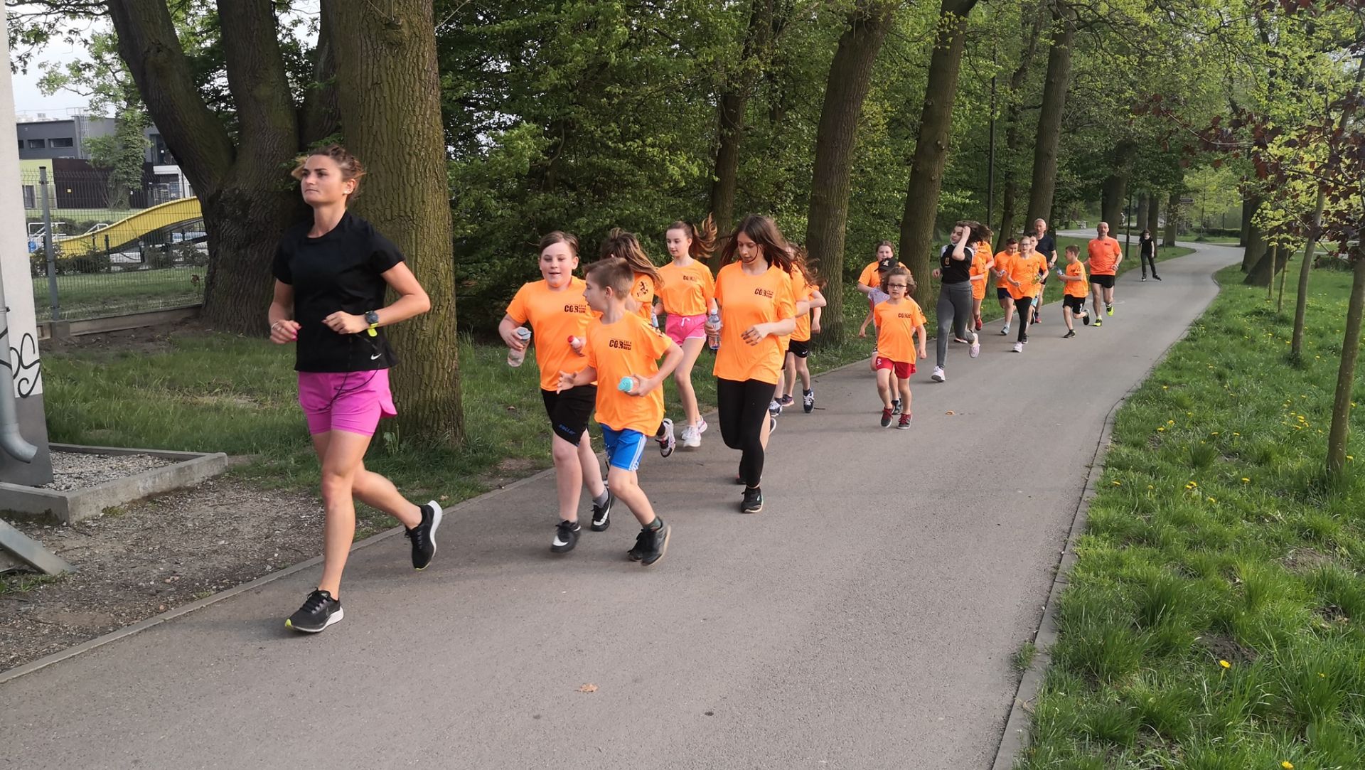 dzieci biegnące z trenerem