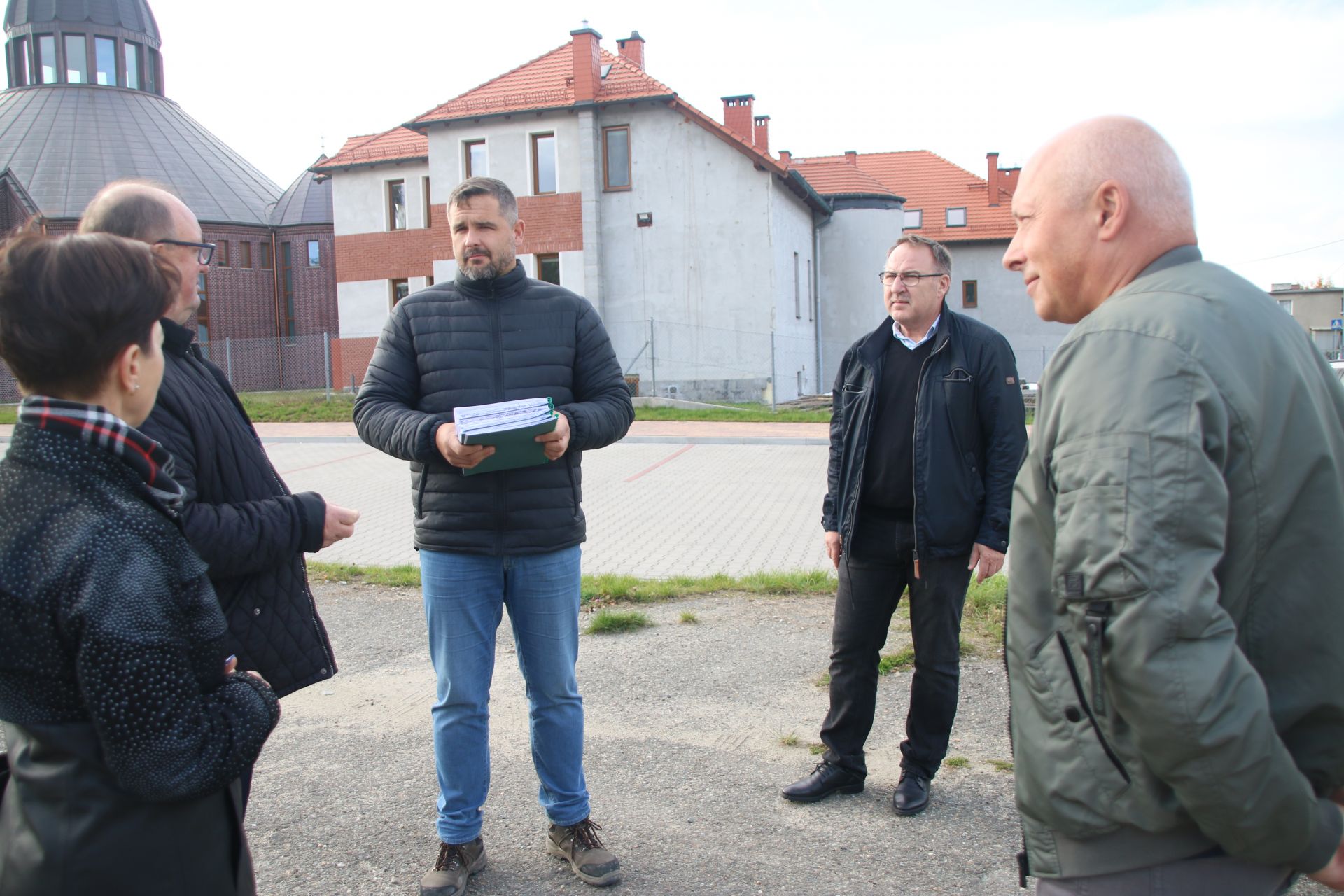 3 mężczyzn rozmawiających na placu