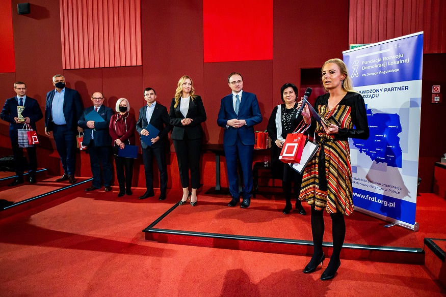 konferencja ludzie w garniturach stoją przy ścianie do zdjęć