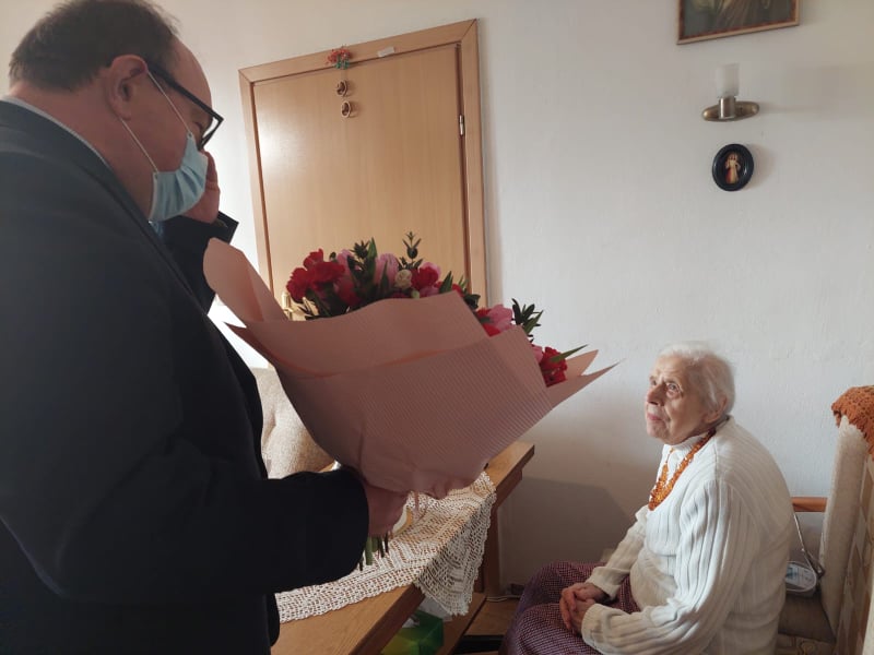 burmistrz wręcza kwiaty jubilatce z okazji 100 urodzin