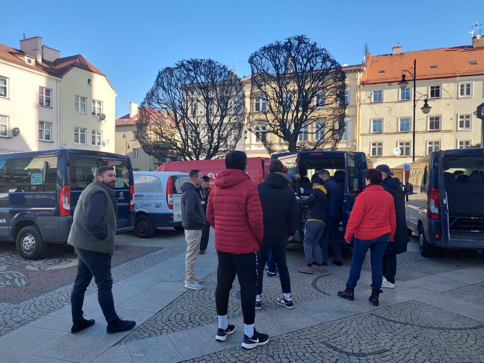 ludzie stojący przy samochodach w rynku